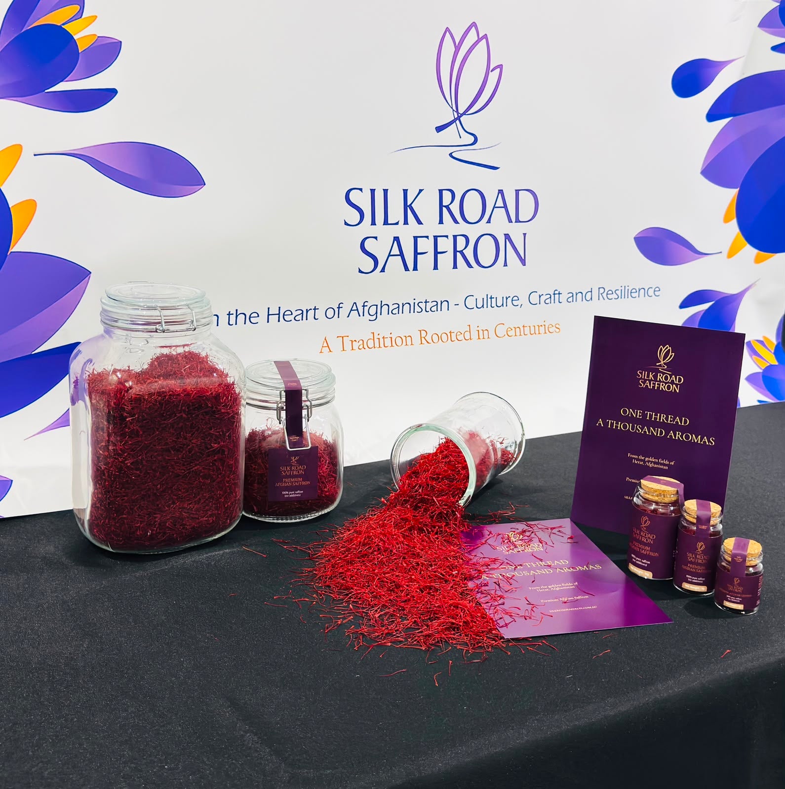 Silk Road Saffron jar collection and loose Afghan saffron threads displayed against the branded backdrop.